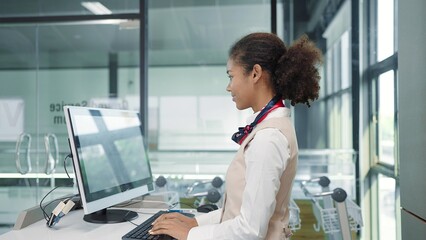 Young american african women airline ground staff worker in uniform working with computer in...