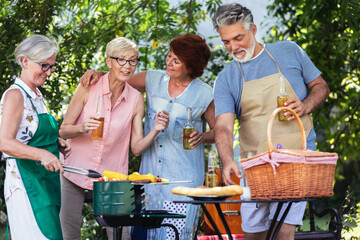 Obraz premium Elderly people celebrate the 4th of July by making barbeque in their backyard