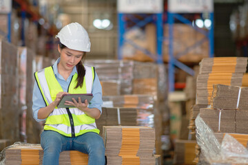 A female manager is checking inventory inside a warehouse.