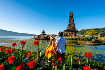 Young couple tourist relaxing and enjoying the beautiful view at Ulun Danu Beratan temple in Bali,...