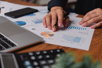 businessman working accountant document graph and chart on desk using calculator for calculate finance report in office.