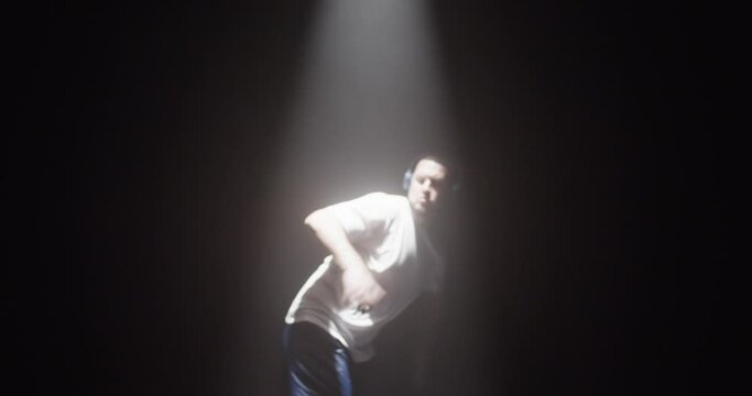 Energetic male dancer in headphones dancing breakdance