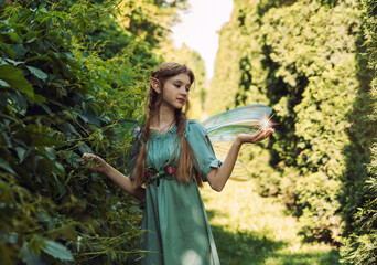 fairy girl with wings walks in the park
