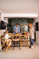 Young family preparing vegetables in the kitchen