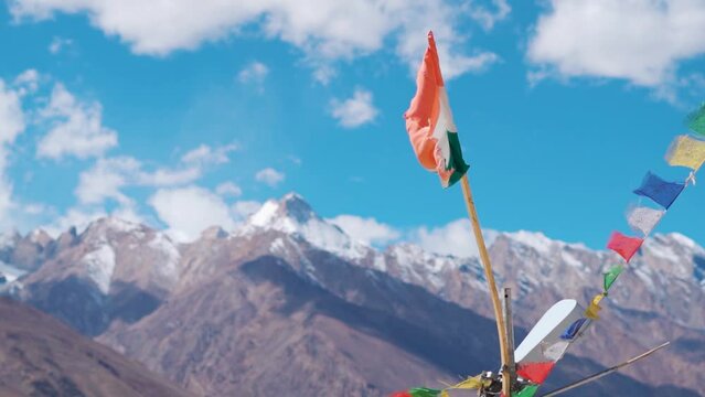 Rack focus shot of Indian flag in front of the snow covered mountains in Padum town in Kargil District at Zanskar Valley, Ladakh, India. Indian flag waves in the kargil district in front of Himalayas.