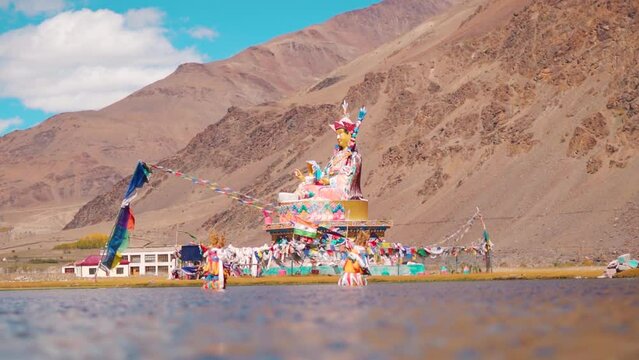 Landscape shot of statue of Guru Padmasambhava in front of the Himalayan mountains at Sani lake near Padum in Zanskar Valley, Ladakh, India. Statue of Buddha in front of the mountains.