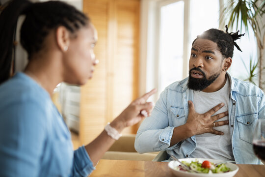 Frustrated black couple arguing while having problems during lunch at home