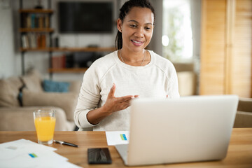 Happy African American woman having a video call over laptop at home