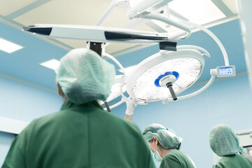 Surgery modern operating room with surgical lamp for emergency save lives.Medical team of surgeons working surgical intervention.Selective focus.