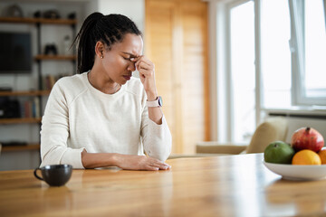 Mid adult African American woman feeling depressed while being alone at home