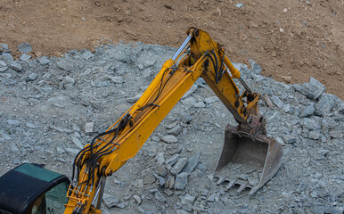 Heavy road construction elevator machine. Excavator shovel at construction site.