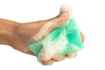 A woman's hand holds a green sponge with soapy foam isolated on a transparent background.