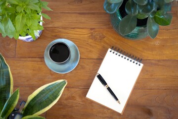 Mockup notebook and pen on wood with plants