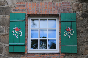 grüne Fensterläden mit Verzierung an einem alten Gebäude