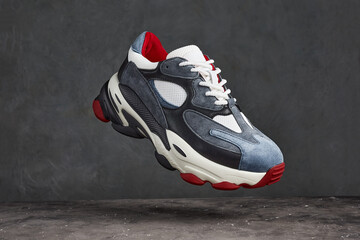 Modern casual sneakers on gray background. Leather trainers on big sole. sport and streetwear trend athletic shoes.