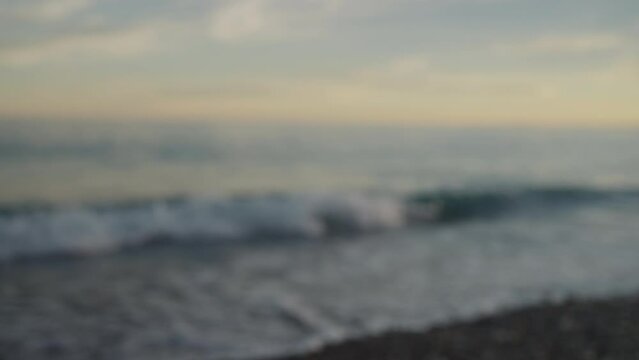 Bokeh blur background shot of sunset on a pebble beach of Nice