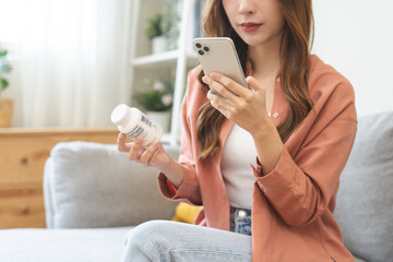 Health care asian young woman using smart phone for reading, searching prescription on bottle medicine, pill label text about information online, instructions side effects, pharmacy medicament concept - obrazy, fototapety, plakaty
