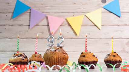 Festive birthday cakes with candles. Birthday background with numbers  92. Anniversary cards on a wooden background.