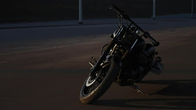 A beautiful motorcycle stands on a footboard for parking. Chrome-plated metal parts. Hobbies of motorcyclists. The bike has big wheels. Motorcycle in the evening sunset. A muffled bike in the evening.