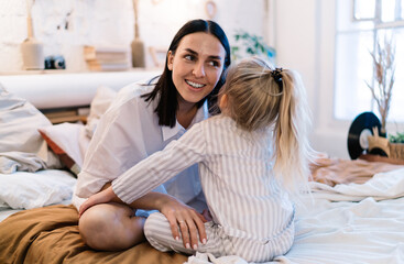 Little girl whispering to mom before bed time