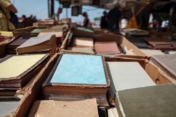Selective focus at stack and row of second hand vintage books are sold at outdoor second hand book store.