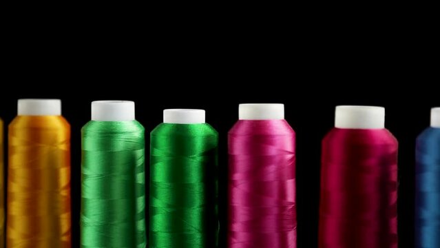 set of different color sewing threads,on black background.
