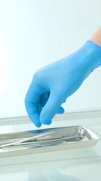 hands in hygienic gloves male female doctor nurse take tools from tray glass table dentistry curette gracie, piezo scaler, piezo scaler attachment, piezo scaler wrench, luxator dentistry cabinet tools