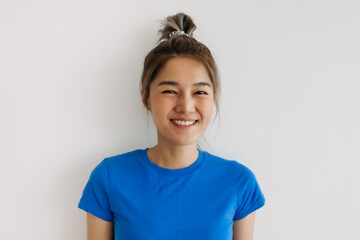 Close up of happy asian woman in blue t-shirt isolated on white.