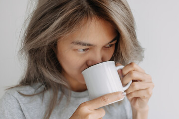 Asian woman drink coffee in the morning on the bed. High quality photo