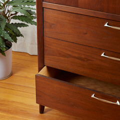 Mid-century modern low dresser. Vintage walnut furniture. Close-up of an open drawer with large...