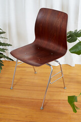 Vintage bentwood desk chair with chrome base. Warm dark wood mid-century modern furniture. Interior...