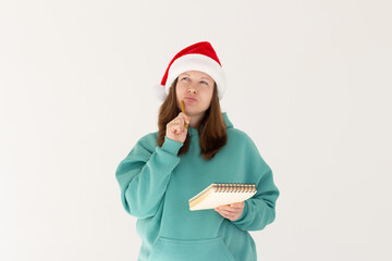 Pregnant brunette woman thinking about her christmas list on white background