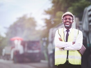 African engineer man or architect checking construction with white safety helmet in construction site. Standing at highway concrete road site