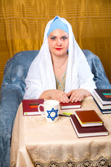 Jewish woman rabbi of the Reform community in a white veil leads a prayer for women in the...