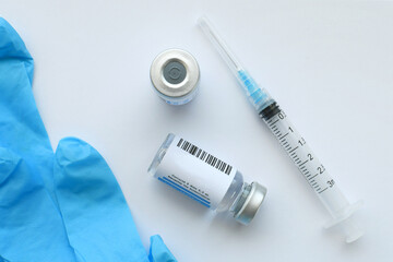 A syringe needle with generic vaccine booster in vial with blank label - mock up copy space  - obrazy, fototapety, plakaty