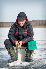 In winter, a man fishes on a frozen river.