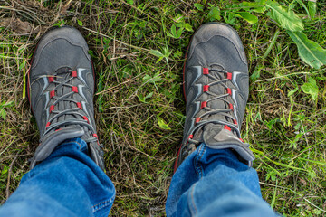 Male wearing walking boots in dense grass