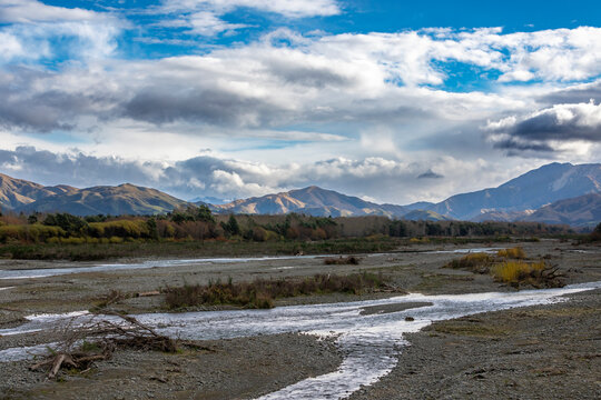 Photograph of a dry river running through a large valley with mountains in the background on the South Island of New Zealand