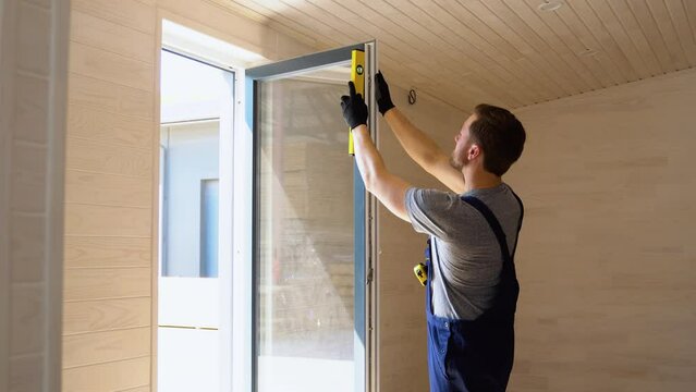 Worker measures of the vertical deviation of pvc windows in wooden mobile home