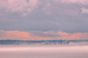fog on frozen lake at sunset