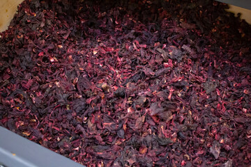 A view of a bin full of hibiscus flowers, on display at a local grocery store.