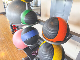 A view of a rack full of medicine balls, seen a in fitness gym setting.