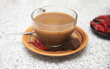 cup of coffee with chocolate and chili red pepper on the table