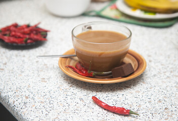 cup of hot coffee with red chili peppers and chocolate