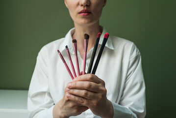 A European woman holds a set of makeup brushes in her hands. A set of makeup brushes in your hands....