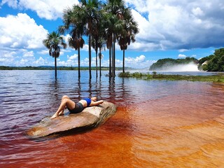 mujer acostada sobre piedra laguna de canaima 