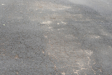 paved road is damaged and uneven.