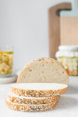 slices of artisan bread loaf, sesame coated bread slices on a marble tray, sandwich bread slices on a tray