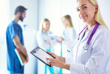 portrait of a young female doctor, with aipads in hand, in a medical office