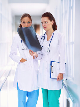 Two woman nurse watching X Ray image, standing in hospital